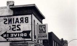 黑白图像的老建筑与大广告画在一边. 牌子上写着脑力25美分