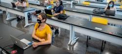 女学生戴着口罩在教室里保持社交距离的照片