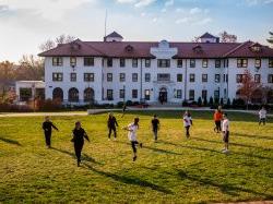 Students playing Frisbee in the quad outside of College Hall.