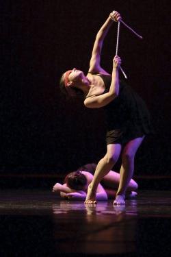 Photo of two dancers, one upright, one on floor.