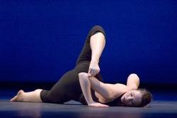 Photo of dancer on the ground in contortionist pose.