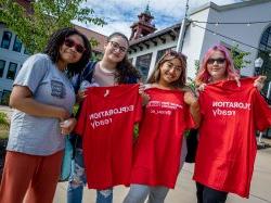 在加州大学预科野餐会上，四名“夏季桥”学生穿着红色t恤在科尔大厅外摆姿势.